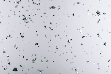 Silver falling confetti on metallic backdrop. Festive and party concept.