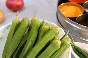 Raw Green Organic Okra or ladies finger Vegetables Ready to Cook with Onion, potatoes, chilies, garlic and Indian Species like Red chili powder, Turmeric powder, black pepper and cumin seeds