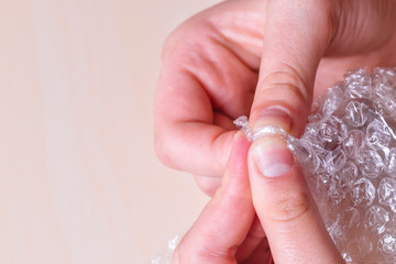 Stress concept. Woman's hands popping bubbles from a bubble paper.