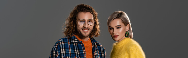 panoramic shot of smiling man and woman in yellow dress isolated on grey