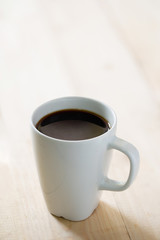 Coffee cup on a blurred wooden board background And free space for entering text image Vertical