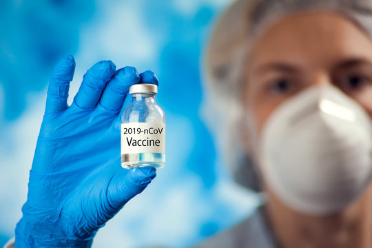 Female doctor holding ampula with coronavirus vaccine. Coronavirus, epidemic and healthcare concept