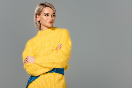 Attractive Woman In Yellow Dress With Crossed Arms Looking Away Isolated On Grey