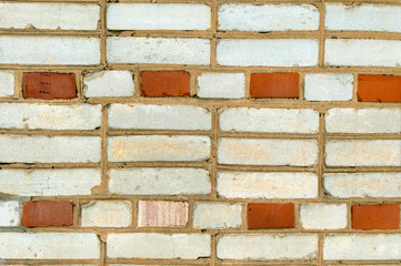 Brickwork of the wall of the building of white and red bricks.