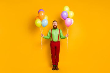Full length photo of astonished imposing charming man hipster go party hold many baloons impressed...
