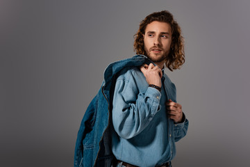 handsome and stylish man in denim shirt looking away isolated on grey