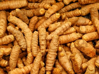 Whole turmeric root food background 