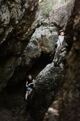 Moody image of young boys exploring cave by the beach at Coral Beach near Shute Harbour in the Whitsundays, Queensland Australia