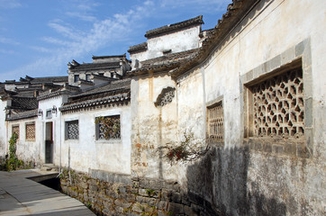 Fototapeta na wymiar Xidi Ancient Town in Anhui Province, China. A quiet street in the old town of Xidi called the Back Rivulet. This path follows a small stream past local houses. Traditional architecture in Xidi, China.