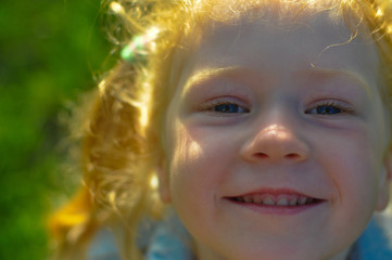horizontal close-up photo of a smiling red-haired girl