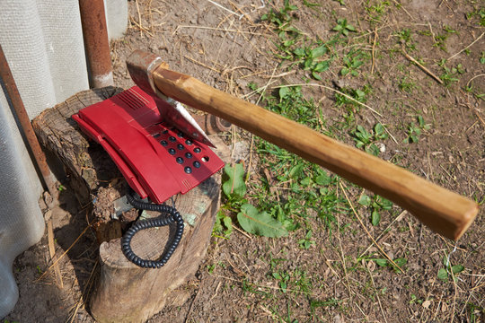 A Large Ax Sticks Out In An Outdated Push-button Telephone.