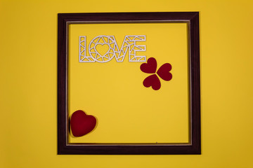 On a yellow background in the frame the word "Love" and red hearts.