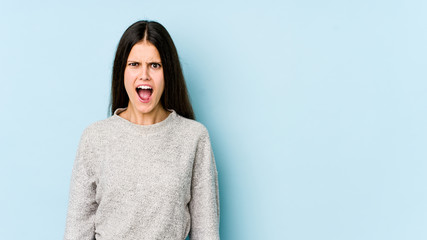 Fototapeta premium Young caucasian woman isolated on blue background shouting very angry, rage concept, frustrated.