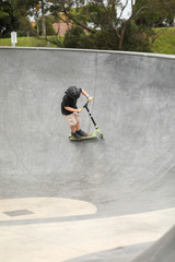 Young boy riding scooter at skate park in Portland, Victoria Australia