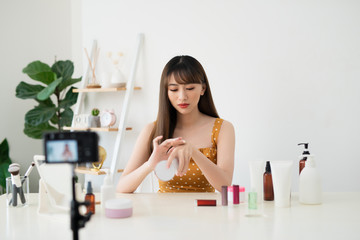 Asian beauty blogger recording video at home