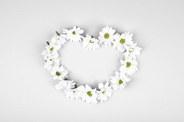Fresh flowers in the shape of a heart on a white background. View from above. Natural cosmetic. place to record. forming a heart shape on a blue wooden background with copy space: spring time concept 