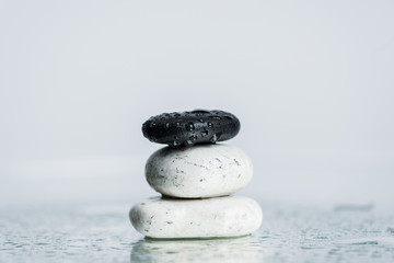 Wet zen stones on glass with water drops isolated on grey