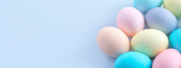 Colorful Easter eggs dyed by colored water isolated on a pale blue background, design concept of Easter holiday activity, close up, copy space.