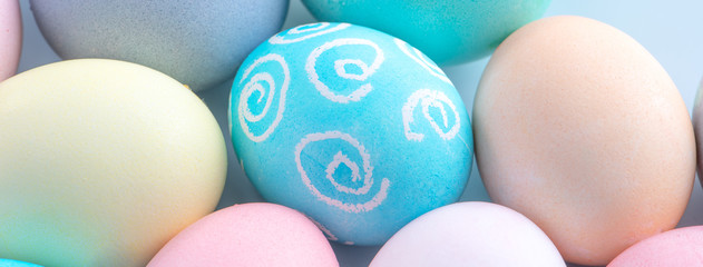 Colorful Easter eggs dyed by colored water isolated on a pale blue background, design concept of Easter holiday activity, close up, copy space.