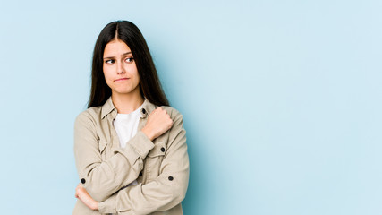 Young caucasian woman isolated on blue background confused, feels doubtful and unsure.