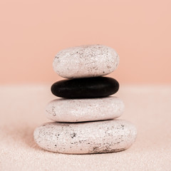 Fototapeta na wymiar Close up view of zen stones on sand on peach background
