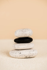 Fototapeta na wymiar Close up view of natural zen stones on sand on beige background