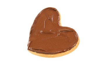 Chocolate nougat cream spread  on a heart shaped bread slice . Isolated on white background.