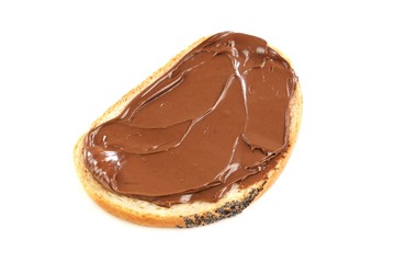 Chocolate nougat cream spread  on a bread slice. Isolated on white background.