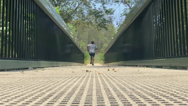 Man Running On A Bridge Away From Camera Low-angle Shot