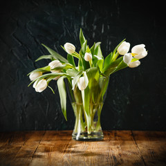 Dark mood background and fresh flowers of tulips.
