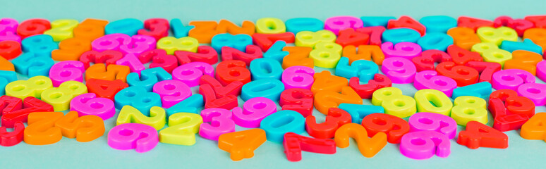 Colorful plastic numbers on blue background, panoramic shot