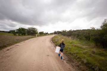 Obraz premium Young boy walking down country lane to go and catch some tadpoles