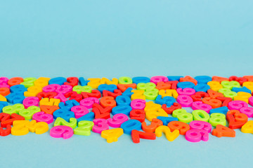 Colorful plastic numbers on blue surface with copy space