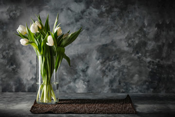 Dark mood background and fresh flowers of tulips.