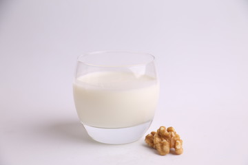 glass of walnut milk in color background