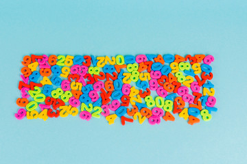 Top view of plastic colorful numbers on blue background