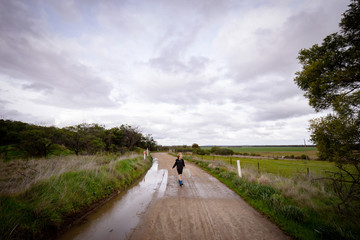 Young boy walking down country lane to go and catch some tadpoles