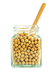 Soybeans in glass jar with wooden spoon isolated on white background..