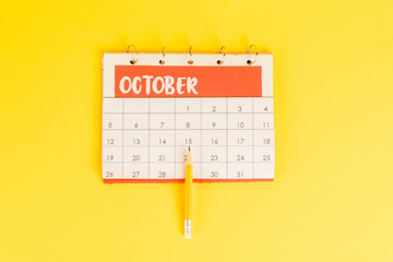 Top view of pencil on calendar with november month on yellow background