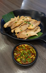 Thai style grilled pork slice serving with spicy chili dipping sauce