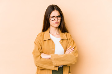 Young caucasian woman isolated on beige background unhappy looking in camera with sarcastic expression.