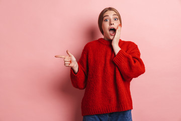 Woman posing isolated over pink wall background pointing.