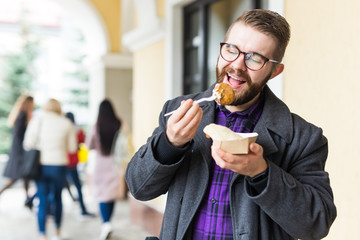 Man holding one-off plate with traditional delicious jewish food falafel made of chickpeas at the...