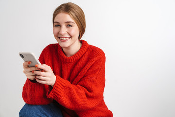 Optimistic young woman using mobile phone.