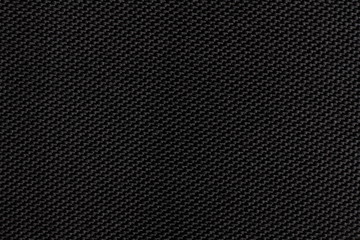 Black dense fabric, background. Close-up.