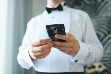groom holding mobile phone