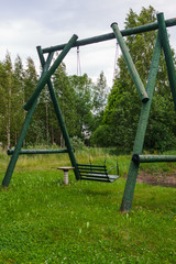 Made from wood, a large rustic swing for entertainment.