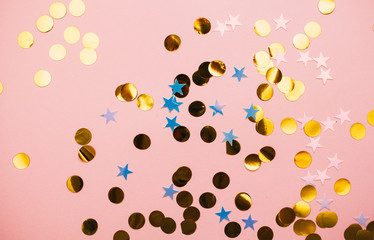 Golden confetti on pink pastel trendy background.