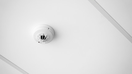 Close up smoke detector on ceiling of building fire alarm system control and copy space