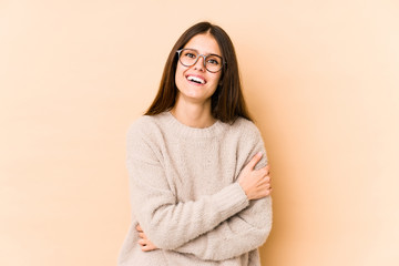 Obraz premium Young caucasian woman isolated on beige background laughing and having fun.